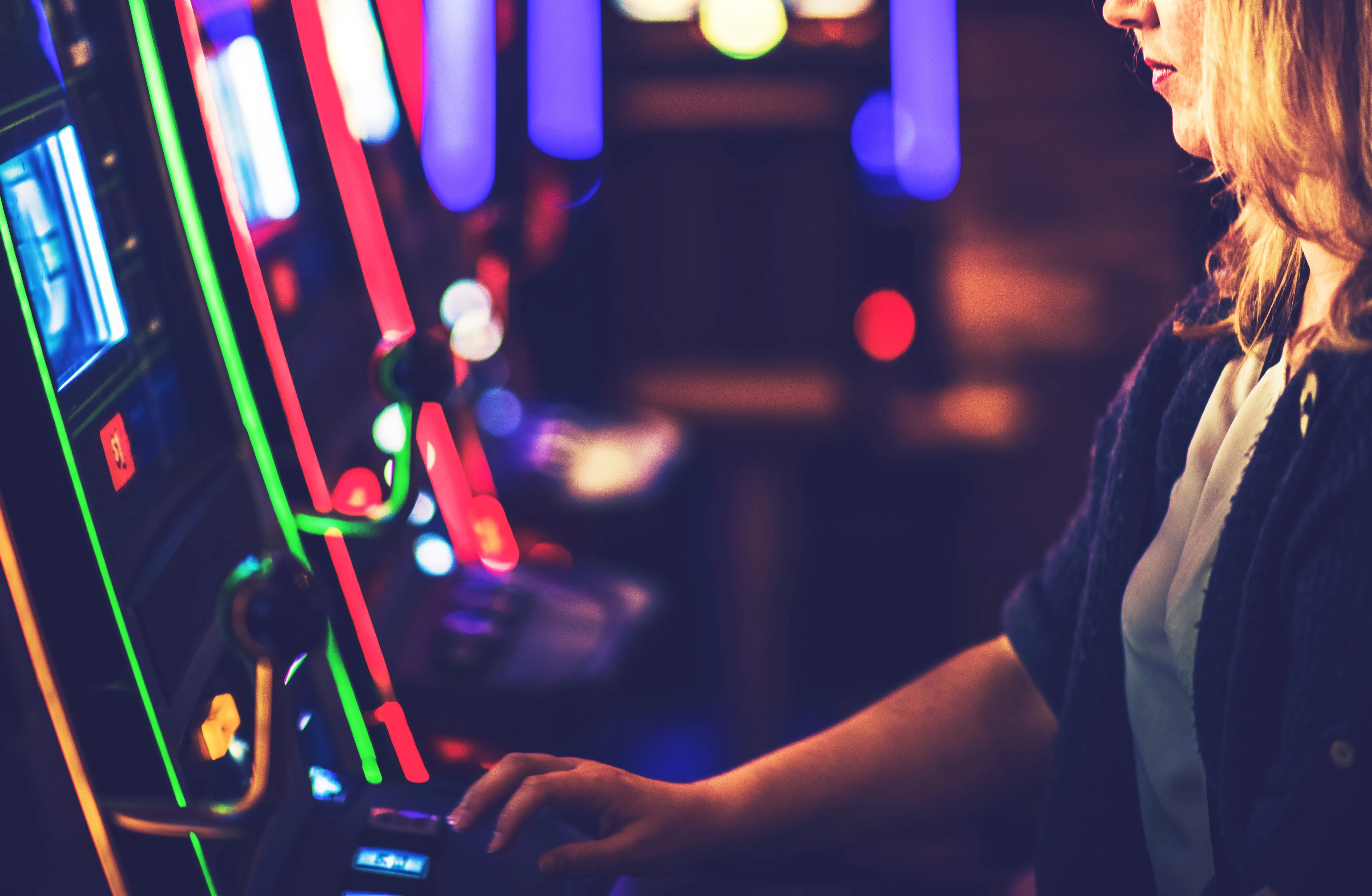 A visitor at a brightly lit pachinko machine