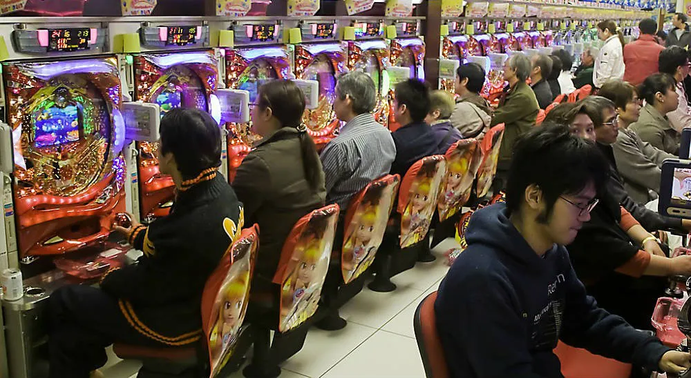 A long row of pachinko machines with players